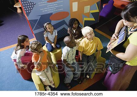 Picture - Teacher reading to group of young children. Fotosearch
