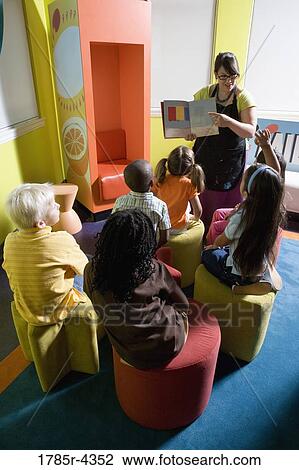 Teacher reading to group of young children View Large Photo Image Stock Image - Teacher reading to group of young children. Fotosearch