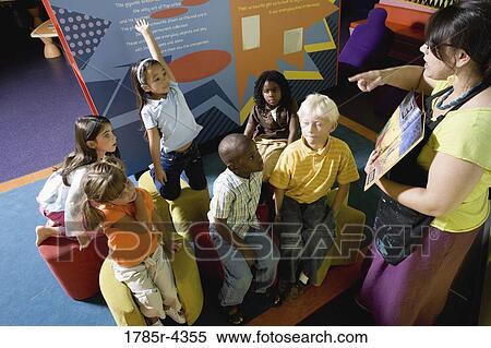 Stock Photography - Teacher reading to group of young children. Fotosearch