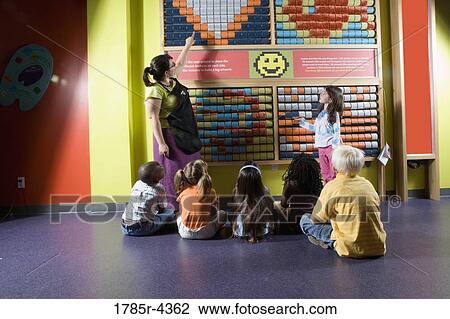 Teacher shows children an interactive art display View Large Photo Image Stock Image - Teacher shows children an interactive art display. Fotosearch