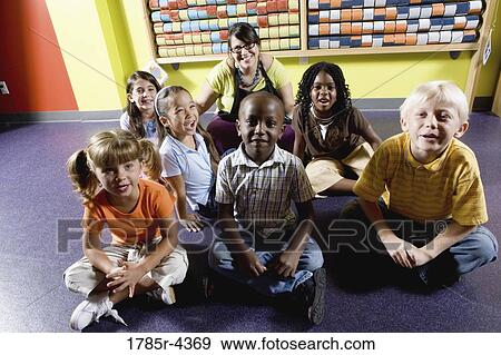 Teacher sitting with young children View Large Photo Image Stock Photo - Teacher sitting with young children. Fotosearch