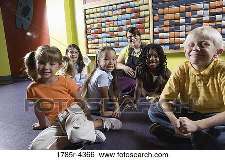 Teacher sitting with young children View Large Photo Image Stock Photograph - Teacher sitting with young children. Fotosearch