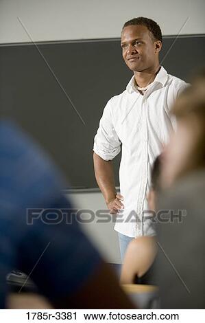Stock Image - Teacher standing in the classroom. Fotosearch