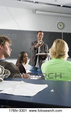 Teacher teaching students in the classroom View Large Photo Image Stock Image - Teacher teaching students in the classroom. Fotosearch