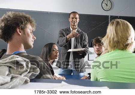 Teacher teaching students in the classroom View Large Photo Image Stock Image - Teacher teaching students in the classroom. Fotosearch
