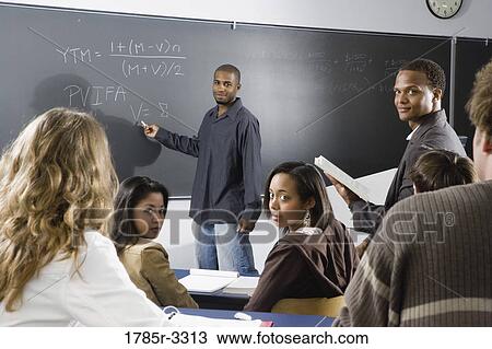 Teacher teaching students in the classroom View Large Photo Image Stock Image - Teacher teaching students in the classroom. Fotosearch