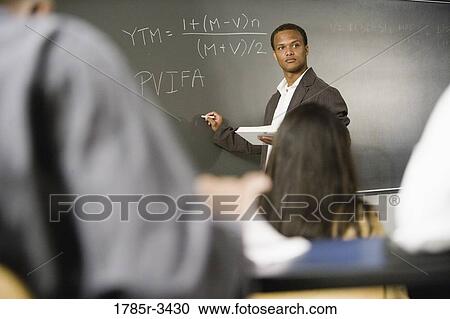 Teacher teaching students in the classroom View Large Photo Image Stock Image - Teacher teaching students in the classroom. Fotosearch