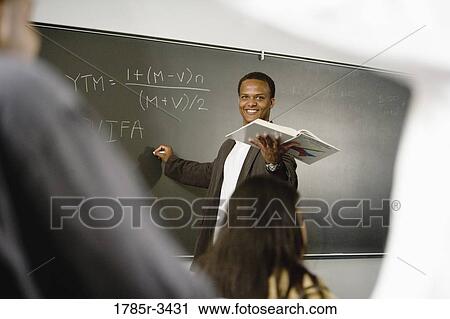 Teacher teaching students in the classroom View Large Photo Image Stock Image - Teacher teaching students in the classroom. Fotosearch