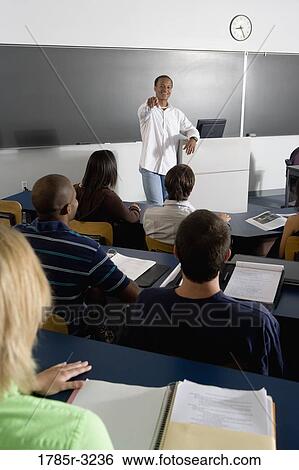 Teacher teaching students in the classroom View Large Photo Image Stock Photograph - Teacher teaching students in the classroom. Fotosearch
