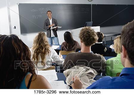 Teacher teaching students in the classroom View Large Photo Image Stock Photograph - Teacher teaching students in the classroom. Fotosearch