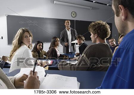 Teacher teaching students in the classroom View Large Photo Image Stock Photograph - Teacher teaching students in the classroom. Fotosearch