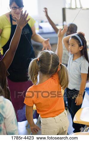 Teacher with her young students in class View Large Photo Image Stock Image - Teacher with her young students in class. Fotosearch
