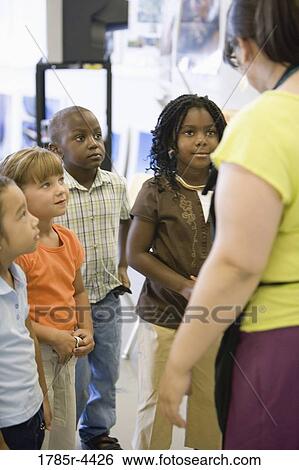 Stock Photograph - Teacher with her young students. Fotosearch