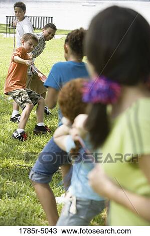 Three boys challenging three girls at tug-of-war at a park View Large Photo Image Stock Image - Three boys challenging three girls at tug-of-war at a park. Fotosearch