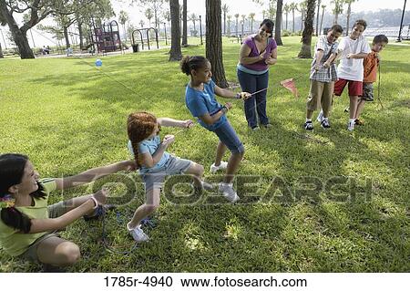 Three girls challenging three boys at a tug-of-war refereed by their teacher View Large Photo Image Stock Image - Three girls challenging three boys at a tug-of-war refereed by their teacher. Fotosearch