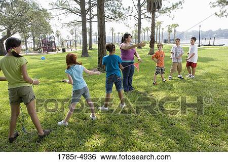 Three girls challenging three boys at a tug-of-war refereed by their teacher View Large Photo Image Stock Photograph - Three girls challenging three boys at a tug-of-war refereed by their teacher. Fotosearch