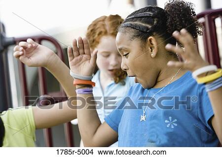 Three girls jumping and dancing at a playground View Large Photo Image Picture - Three girls jumping and dancing at a playground. Fotosearch