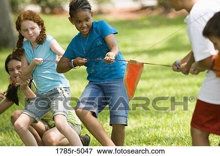 Three girls pulling hard at tug-of-war at a park View Large Photo Image Stock Photo - Three girls pulling hard at tug-of-war at a park. Fotosearch