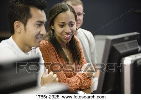 Three university students using computer View Large Photo Image Stock Photo - Three university students using computer. Fotosearch
