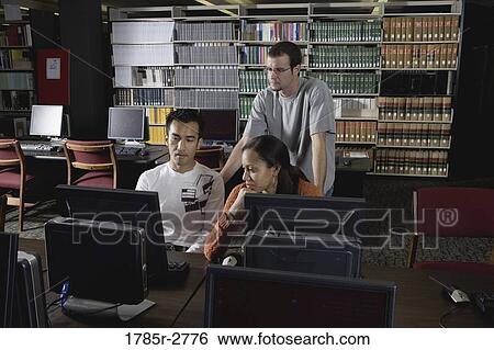 Three university students using computers in the library View Large Photo Image Stock Photograph - Three university students using computers in the library. Fotosearch