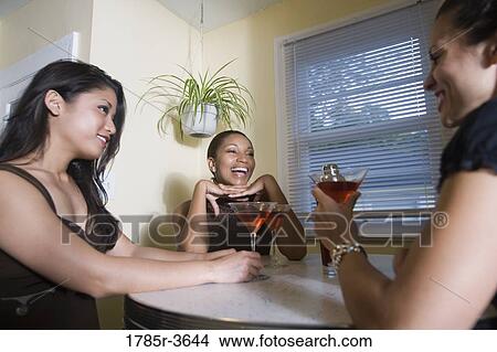 Three women having drinks in kitchen View Large Photo Image Picture - Three women having drinks in kitchen. Fotosearch