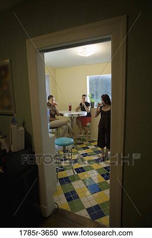 Three women having drinks in kitchen View Large Photo Image Stock Image - Three women having drinks in kitchen. Fotosearch
