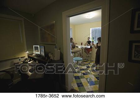 Three women having drinks in kitchen next to home office View Large Photo Image Stock Image - Three women having drinks in kitchen next to home office. Fotosearch