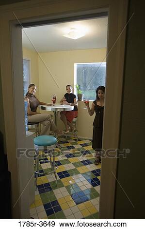 Three women having drinks in kitchen View Large Photo Image Stock Photo - Three women having drinks in kitchen. Fotosearch