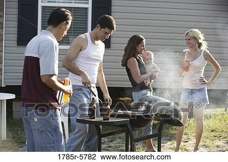 Two blue-collar families enjoying a cookout in front of a trailer home View Large Photo Image Stock Image - Two blue-collar families enjoying a cookout in front of a trailer home. Fotosearch