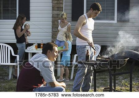 Two blue-collar families enjoying a cookout in front of a trailer home View Large Photo Image Stock Image - Two blue-collar families enjoying a cookout in front of a trailer home. Fotosearch