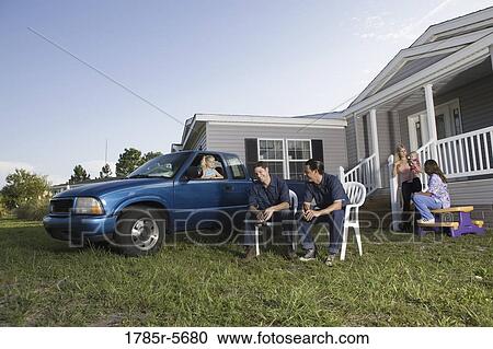 Two blue-collar families sitting on front lawn of trailer home View Large Photo Image Stock Image - Two blue-collar families sitting on front lawn of trailer home. Fotosearch