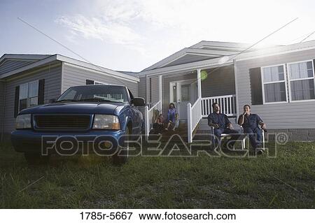 Two blue-collar families sitting on front lawn of trailer home View Large Photo Image Stock Photo - Two blue-collar families sitting on front lawn of trailer home. Fotosearch