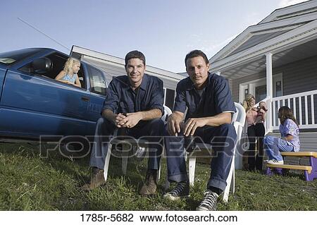 Two blue-collar men holding cold drinks sitting on lawn chairs in front of trailer home View Large Photo Image Stock Image - Two blue-collar men holding cold drinks sitting on lawn chairs in front of trailer home. Fotosearch