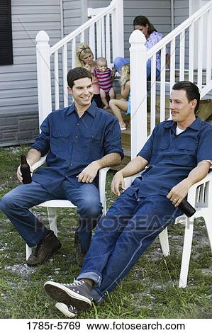 Two blue-collar men sitting in front of trailer home View Large Photo Image Stock Photo - Two blue-collar men sitting in front of trailer home. Fotosearch