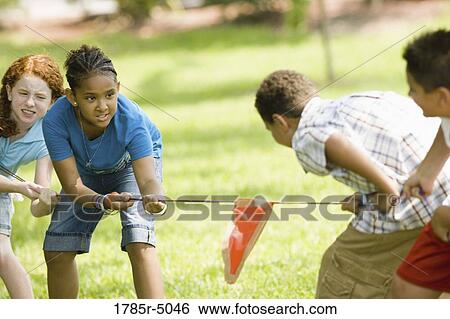 Two boys challenging two girls at tug-of-war at a park View Large Photo Image Stock Photograph - Two boys challenging two girls at tug-of-war at a park. Fotosearch