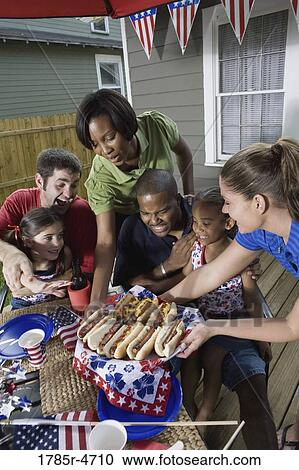 Two families on backyard patio enjoying a cookout on the 4th of July View Large Photo Image Stock Image - Two families on backyard patio enjoying a cookout on the 4th of July. Fotosearch