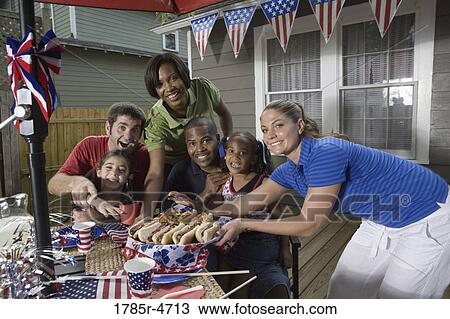 Two families on backyard patio enjoying a cookout on the 4th of July View Large Photo Image Stock Image - Two families on backyard patio enjoying a cookout on the 4th of July. Fotosearch
