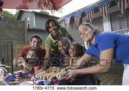 Two families on backyard patio enjoying a cookout on the 4th of July View Large Photo Image Stock Photography - Two families on backyard patio enjoying a cookout on the 4th of July. Fotosearch