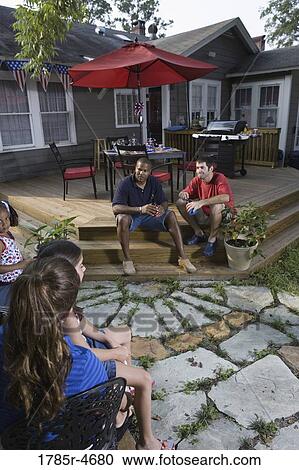 Two families on backyard patio relaxing with cold drinks View Large Photo Image Stock Image - Two families on backyard patio relaxing with cold drinks. Fotosearch