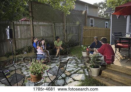 Two families on backyard patio relaxing with cold drinks View Large Photo Image Stock Image - Two families on backyard patio relaxing with cold drinks. Fotosearch