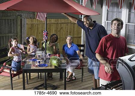 Two families on backyard patio celebrating 4th of July View Large Photo Image Stock Image - Two families on backyard patio celebrating 4th of July. Fotosearch
