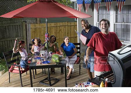 Two families on backyard patio celebrating 4th of July View Large Photo Image Stock Image - Two families on backyard patio celebrating 4th of July. Fotosearch