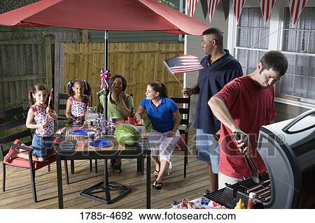 Two families on backyard patio celebrating 4th of July View Large Photo Image Stock Image - Two families on backyard patio celebrating 4th of July. Fotosearch