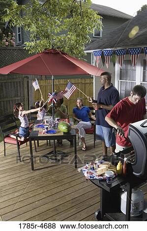 Two families on backyard patio celebrating 4th of July View Large Photo Image Stock Photo - Two families on backyard patio celebrating 4th of July. Fotosearch
