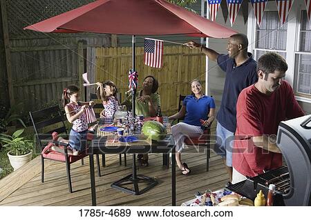 Two families on backyard patio celebrating 4th of July View Large Photo Image Stock Photo - Two families on backyard patio celebrating 4th of July. Fotosearch