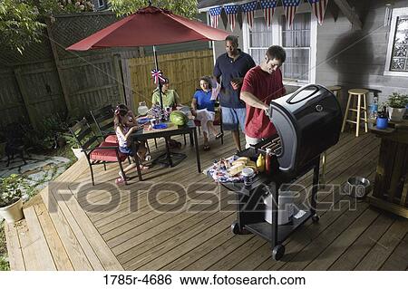 Two families on backyard patio celebrating 4th of July View Large Photo Image Stock Photograph - Two families on backyard patio celebrating 4th of July. Fotosearch