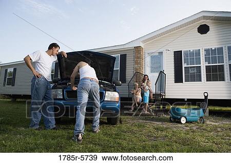 Two men looking under the hood of a pickup truck in front of trailer home View Large Photo Image Stock Photo - Two men looking under the hood of a pickup truck in front of trailer home. Fotosearch