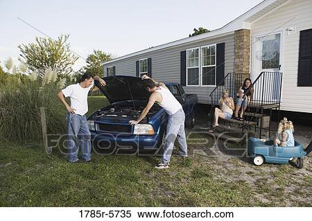 Two men looking under the hood of a pickup truck in front of trailer home View Large Photo Image Stock Photography - Two men looking under the hood of a pickup truck in front of trailer home. Fotosearch