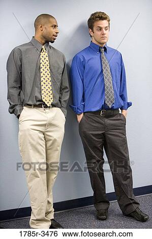 Stock Photograph - Two young businessmen standing. Fotosearch