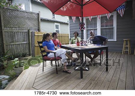 Two young couples on backyard patio on 4th of July View Large Photo Image Stock Image - Two young couples on backyard patio on 4th of July. Fotosearch